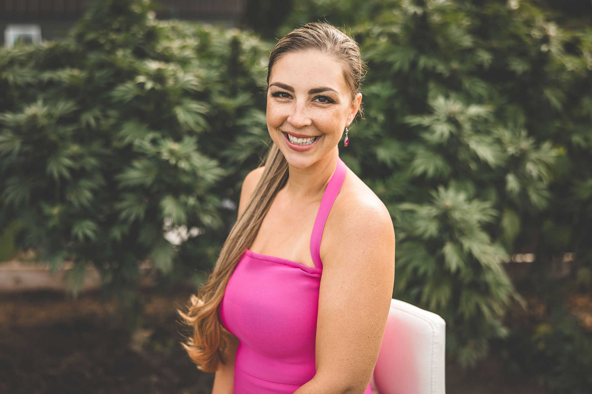 A picture of Emily Kyle with a growing cannabis plant.