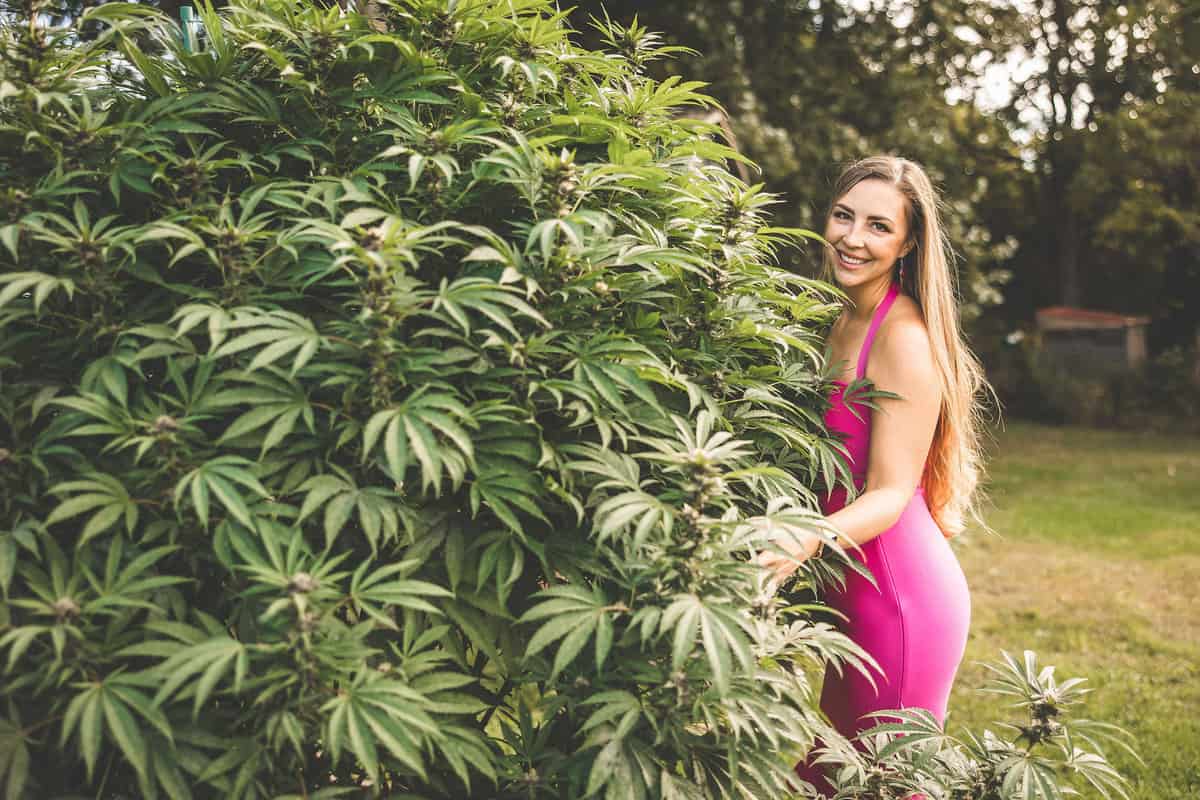 A picture of Emily Kyle with a growing cannabis plant.