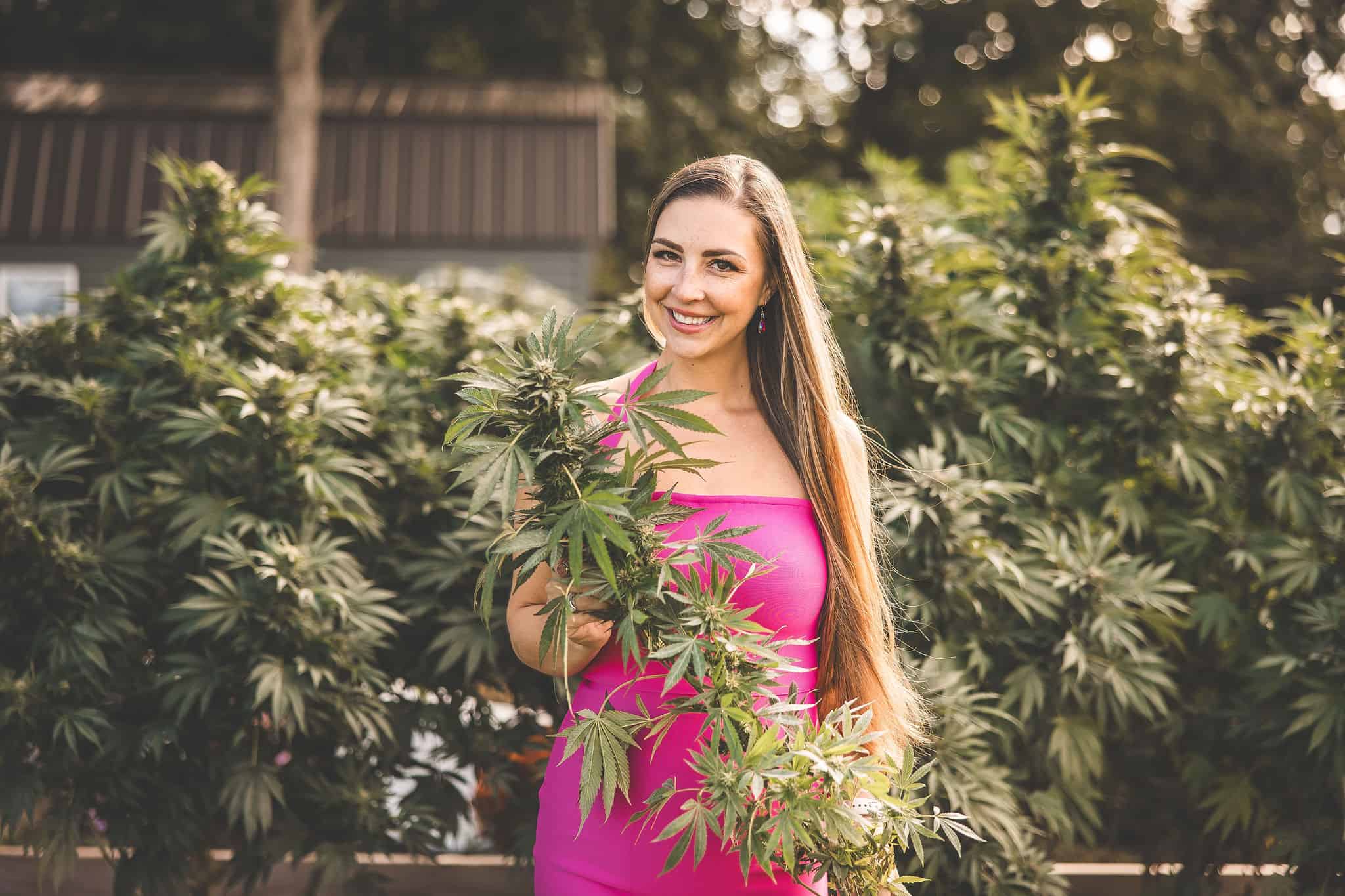 A picture of Emily Kyle with a growing cannabis plant.