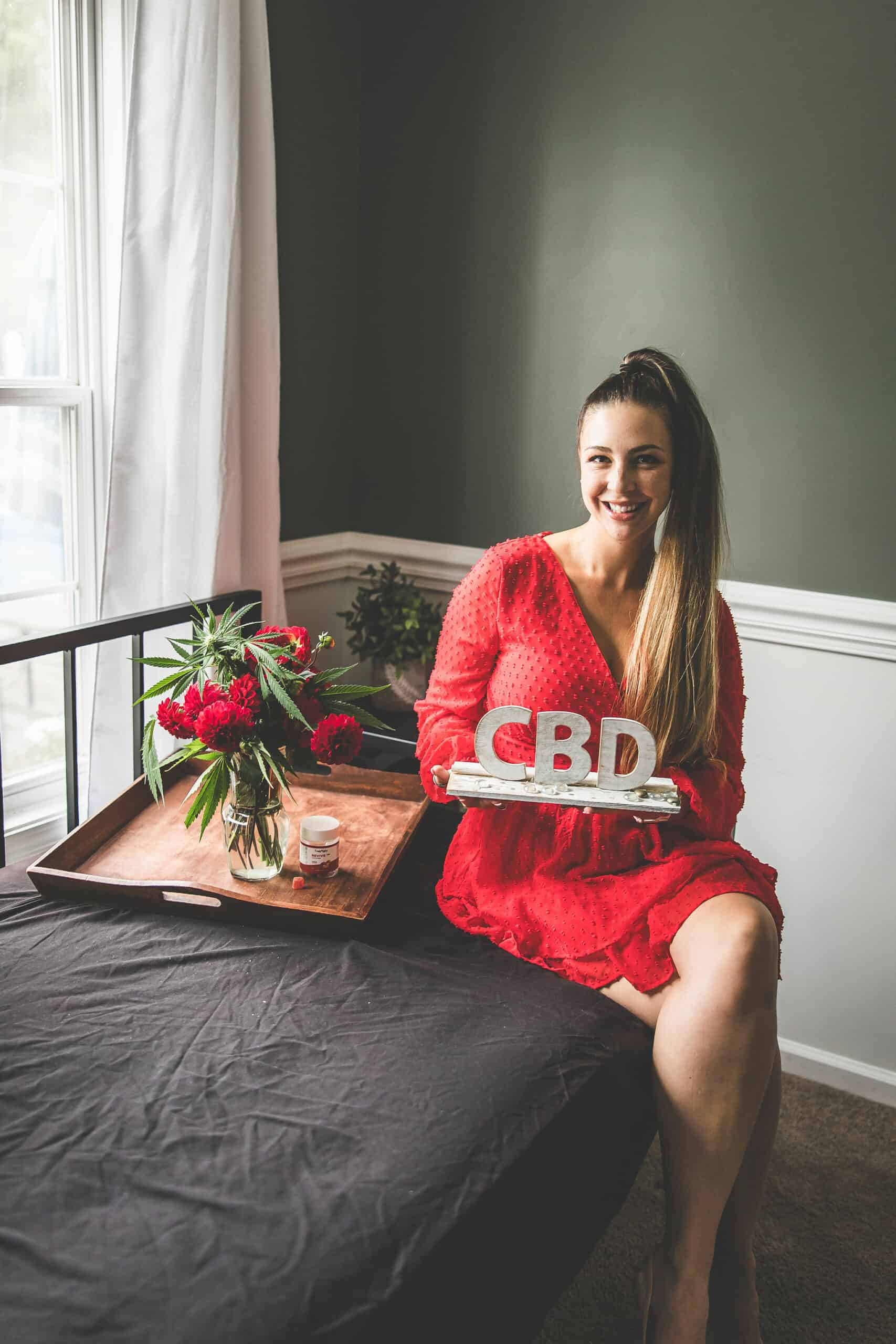 A picture of Emily Kyle holding a CBD sign.