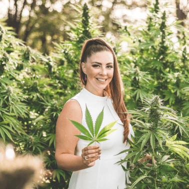 A picture of Emily Kyle holding a cannabis leaf.