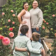Healthy family enjoying time together in a garden with blooming roses.